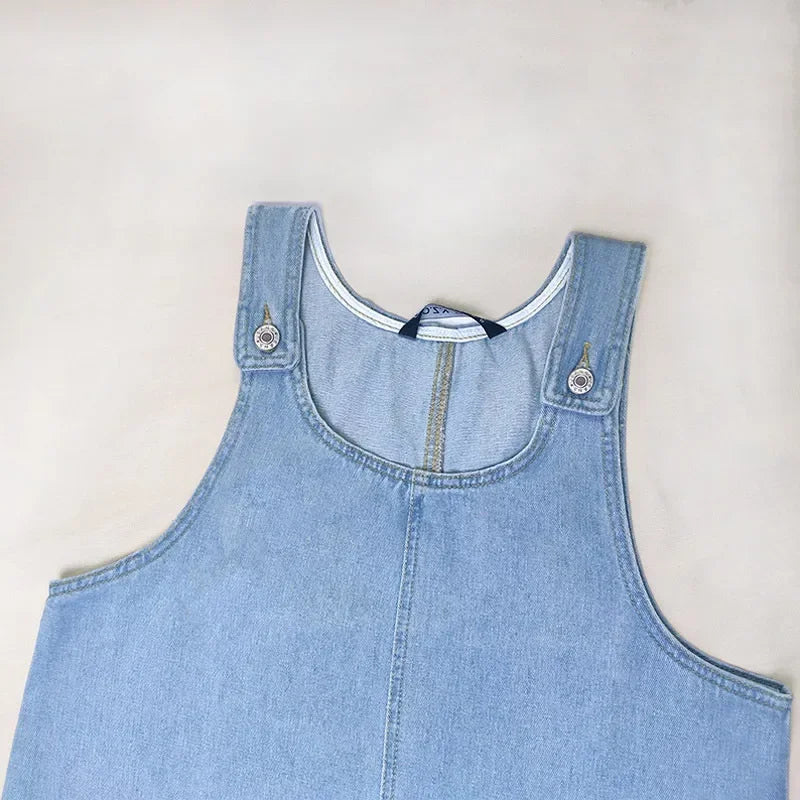 Saphira | Denim­miniklänning med axelbandsknäppning och patchfickor